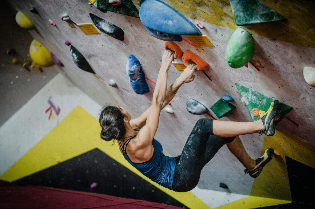 Person climbing inside an indoor rock climbing center.