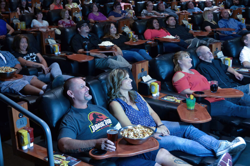 People enjoying a movie the the theater.