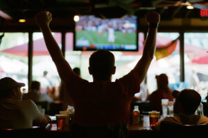 A fan cheering in a restaurant during a game